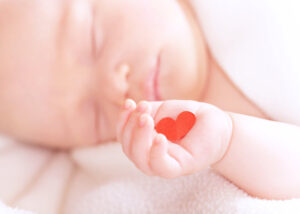 Photo of baby holding paper heart